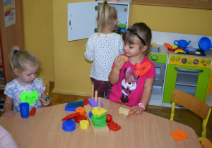 Dziewczynki bawią sie zabawkami przy stoliku
